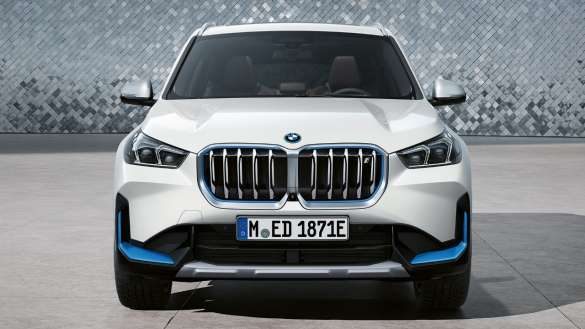 BMW iX1 U11 BEV 2022 Mineralweiß metallic Frontansicht parkend vor Discokugelwand